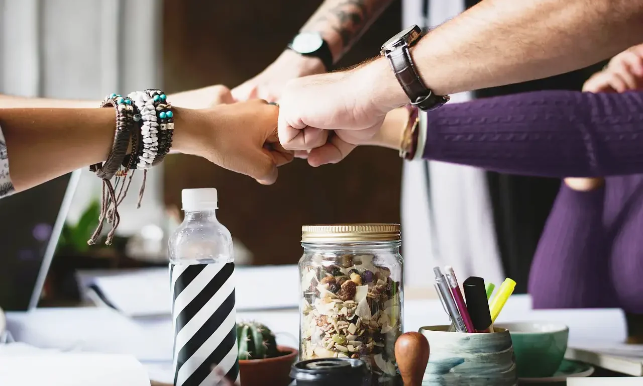 gruppo di professionisti che lavorano in team e si danno il pugno come simbolo di sinergia